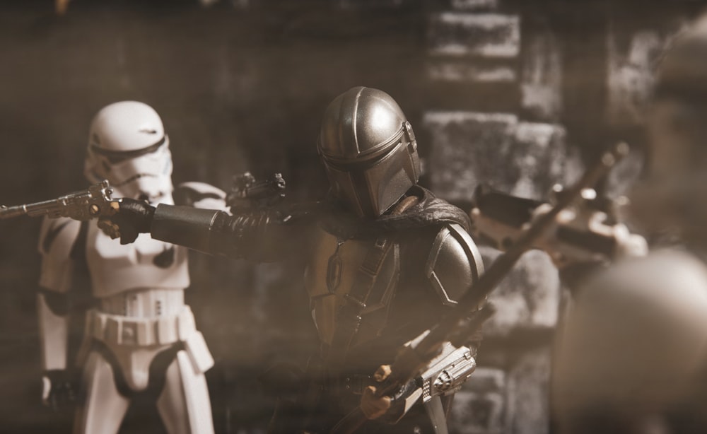 grayscale photo of man in black helmet holding rifle