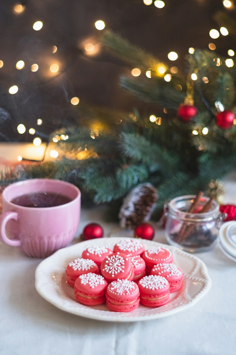 pink ceramic mug beside clear glass bowl with red round fruits