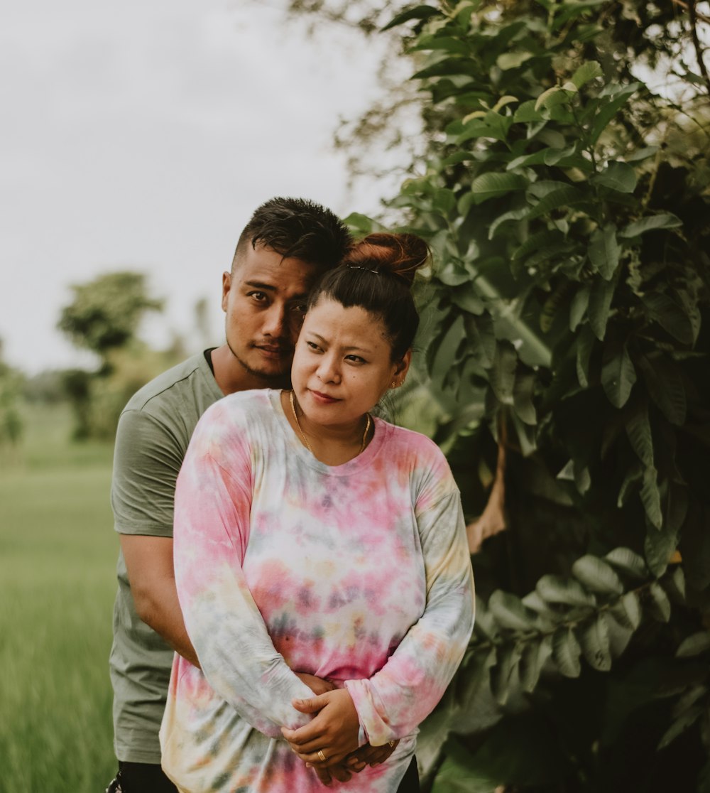 woman in pink and white crew neck t-shirt standing near green plants during daytime