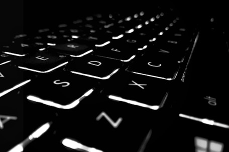 Close-up of hands typing on a modern keyboard with highlighted keys and smooth animations.