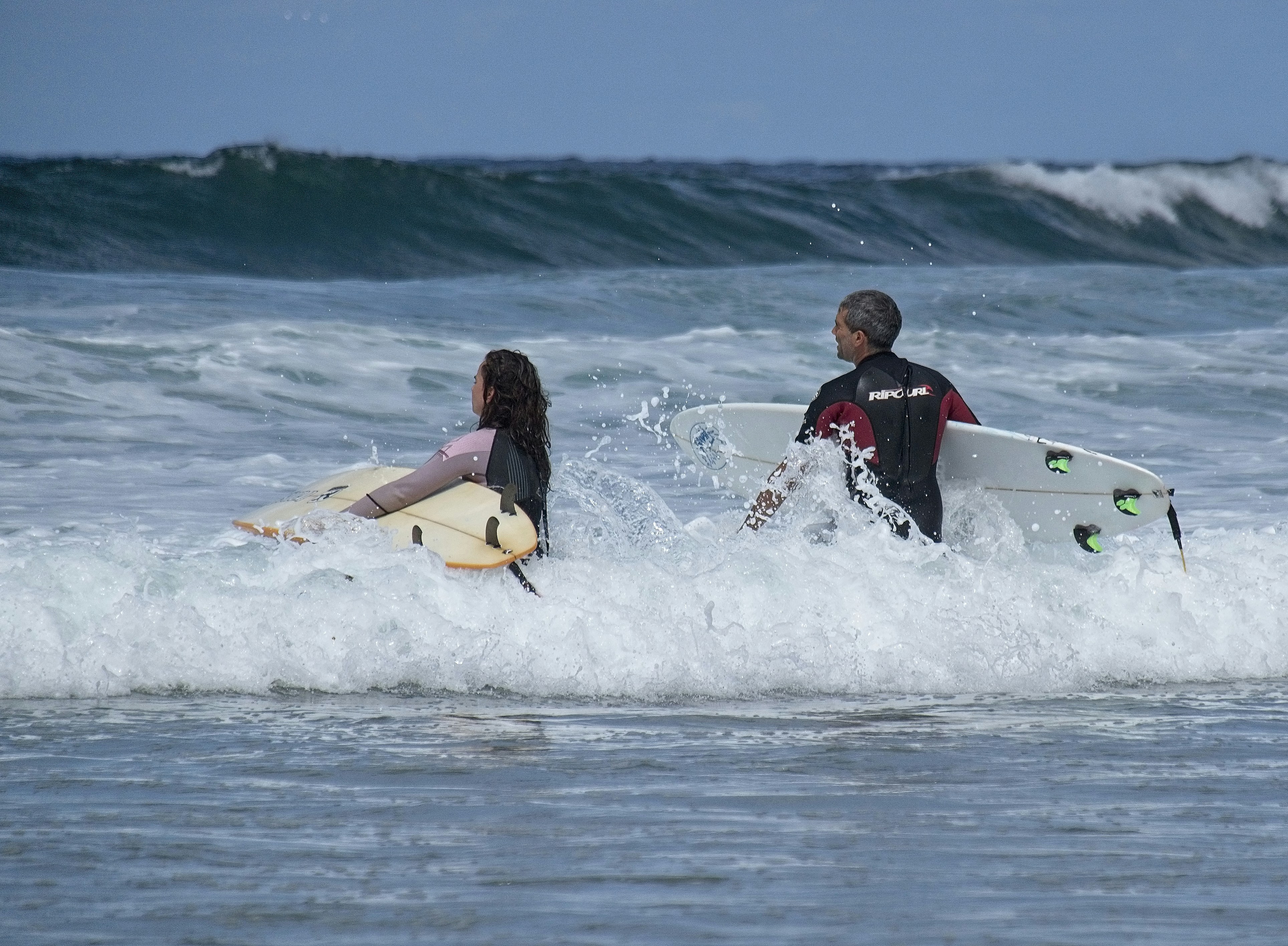 man in red and black wet suit riding white and yellow surfboard on sea during daytime