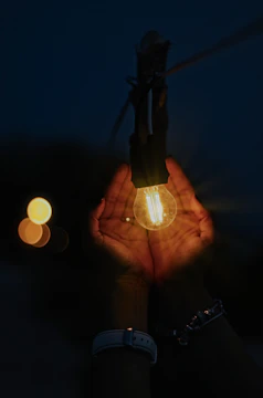 Artisan hands carefully assembling a custom light art piece under soft cinematic lighting.