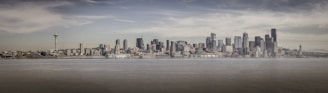 A panoramic view of Vancouver's waterfront with highrises reflecting in the water on a clear day.