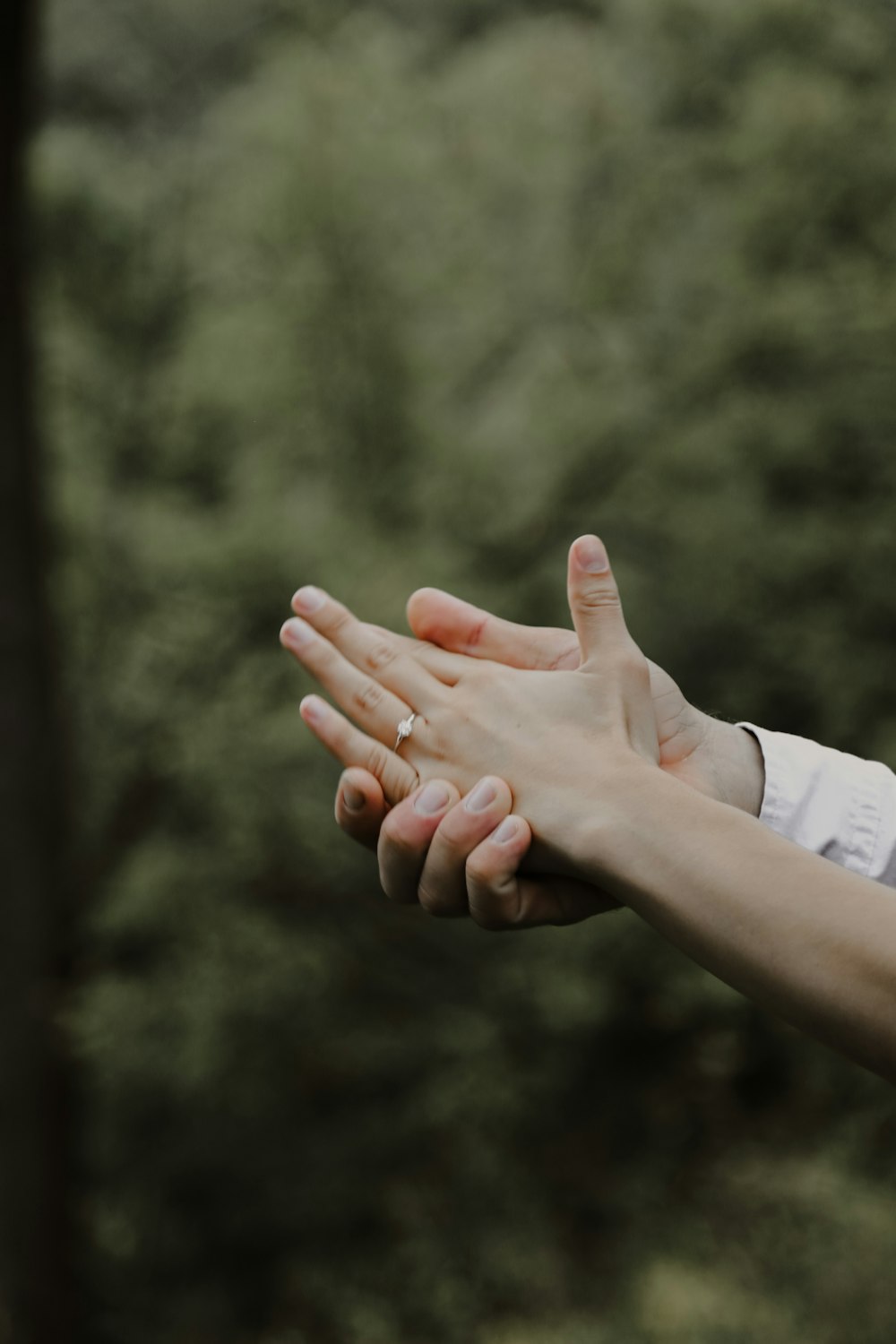 person in white long sleeve shirt showing left hand