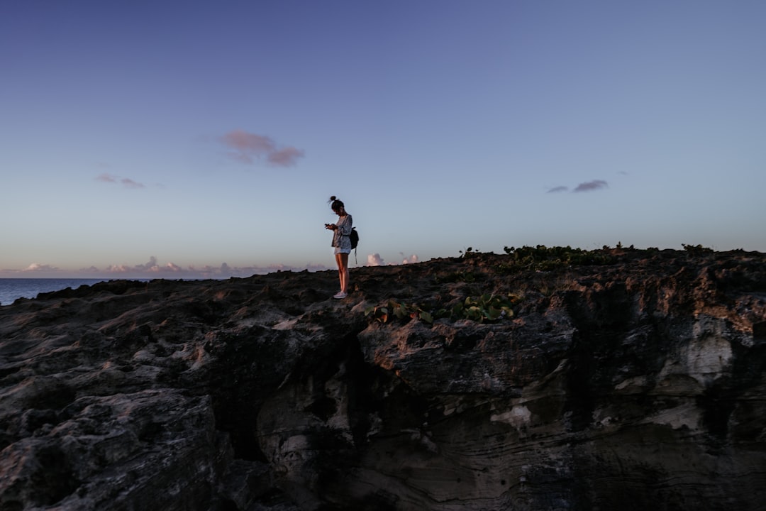 man in black shirt standing on rock formation during daytime