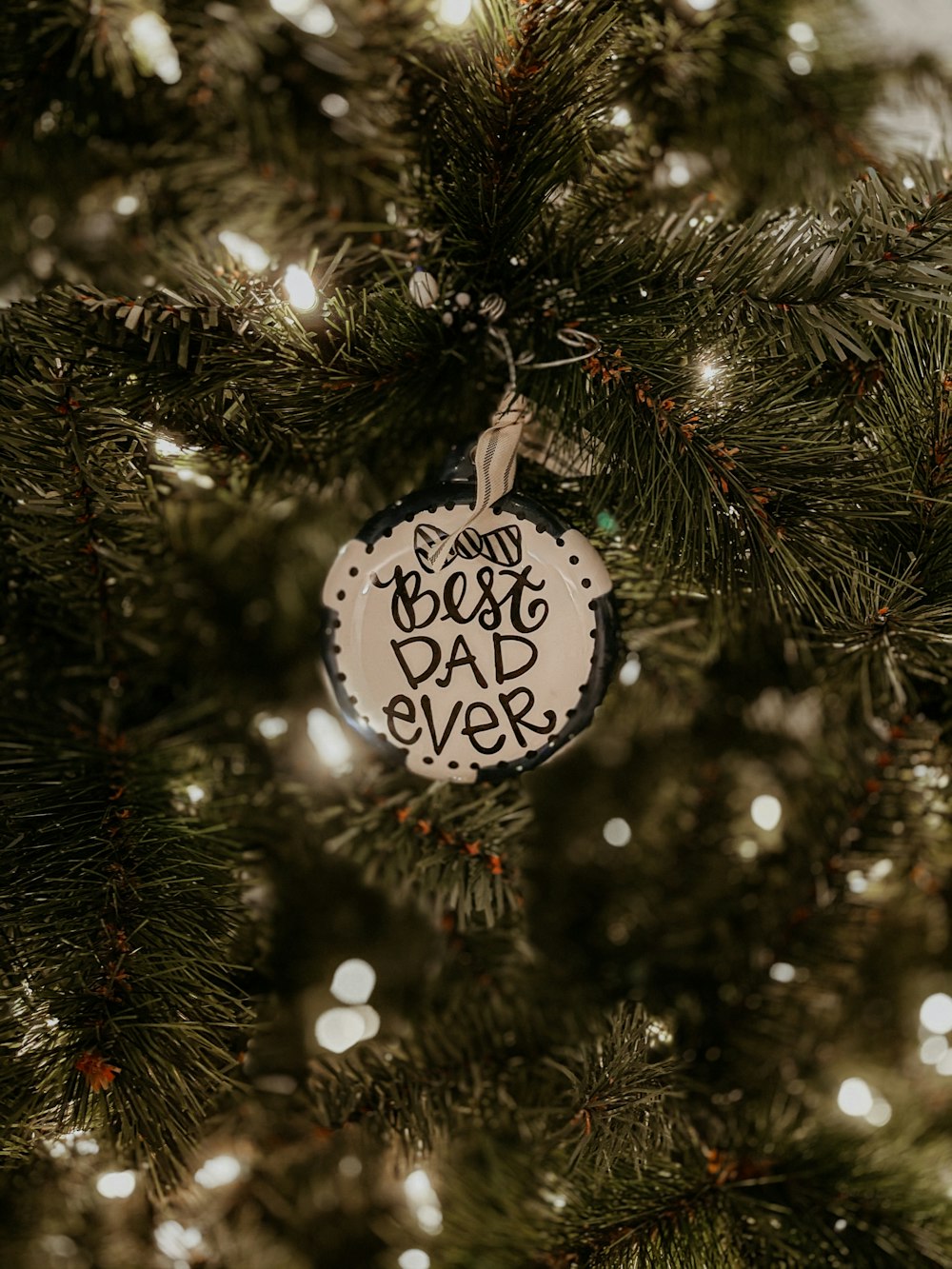 Boule de Noël blanche et noire sur sapin de Noël vert