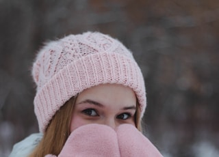 woman in white jacket and pink knit cap