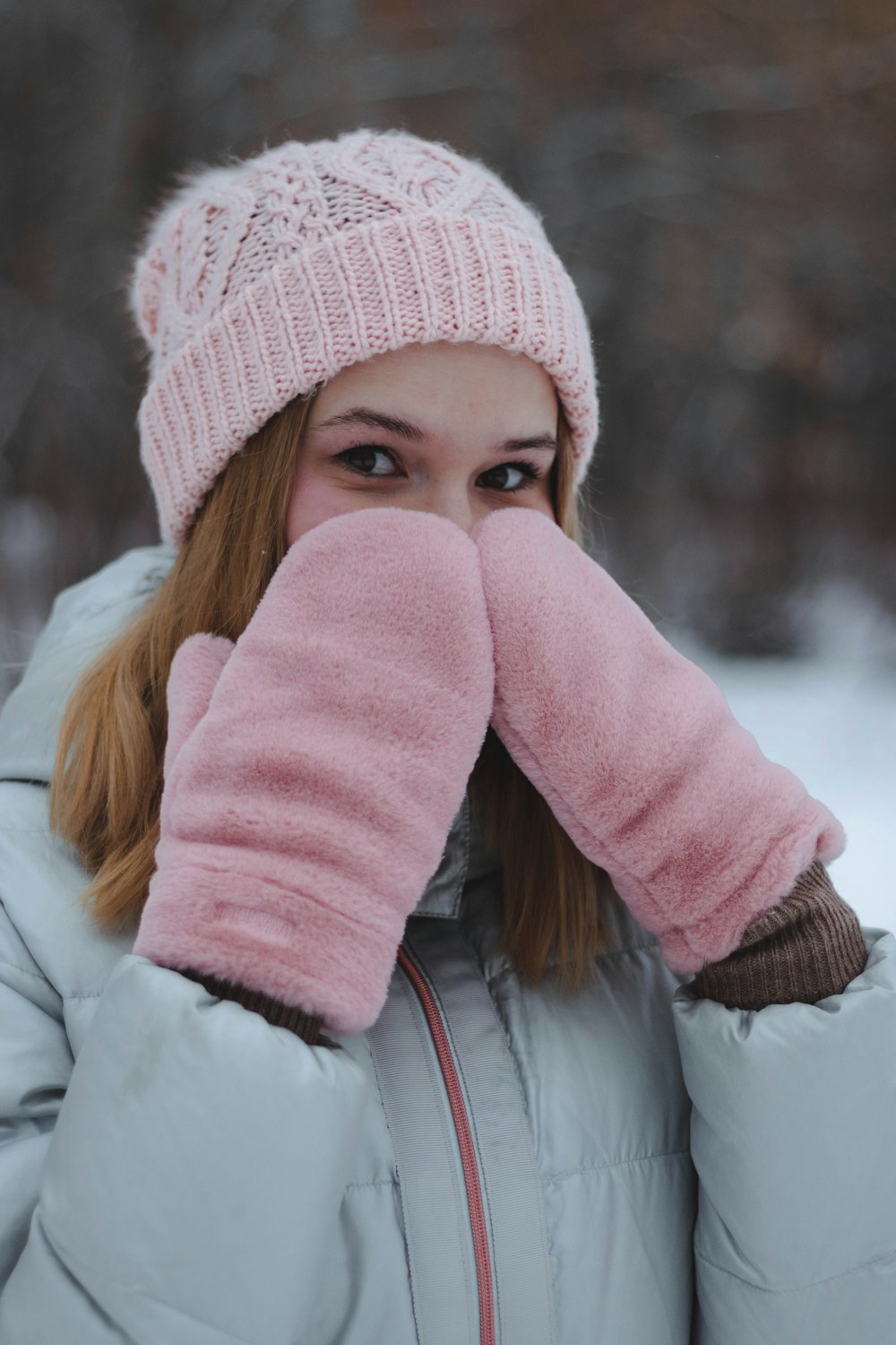 woman in white jacket and pink knit cap
