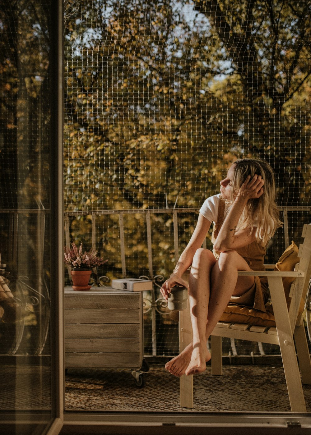 woman in white shirt sitting on brown wooden chair