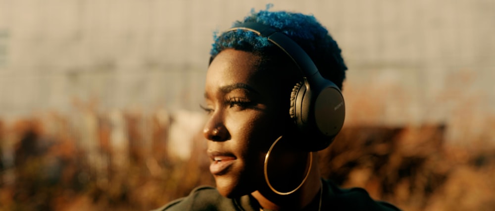 woman in brown shirt wearing black headphones