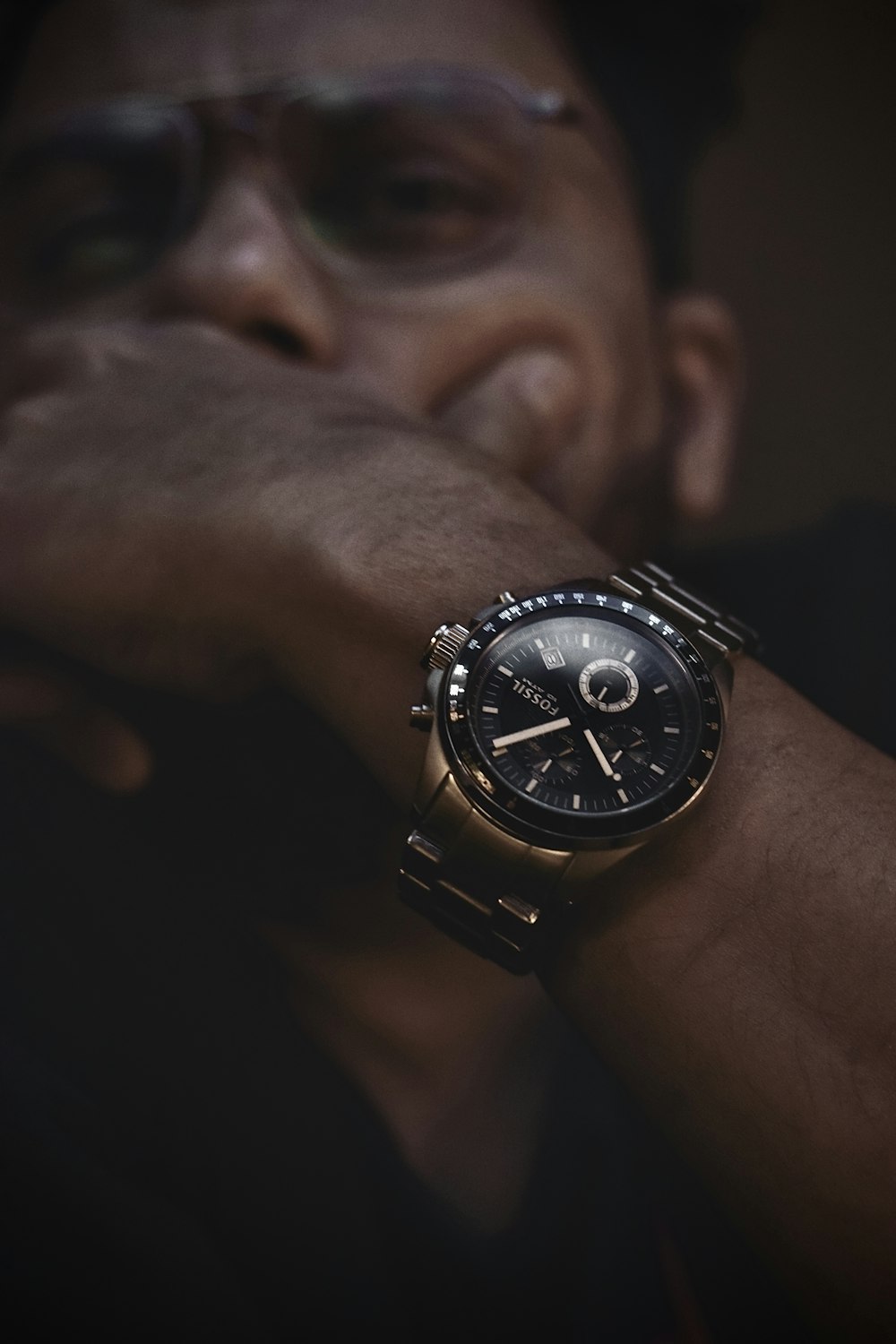 person wearing black and silver round chronograph watch