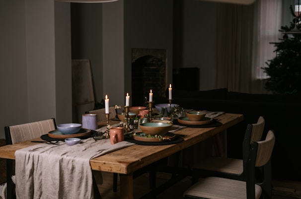 A cozy dining table set with warm lighting and tableware.