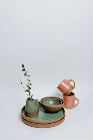 A set of vintage pottery jars arranged artistically against a minimalist white background.