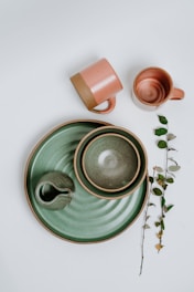 green ceramic mug on green ceramic saucer