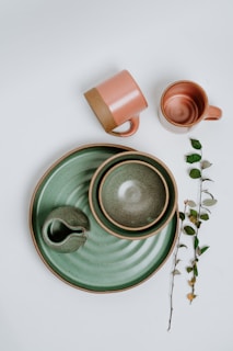 green ceramic mug on green ceramic saucer