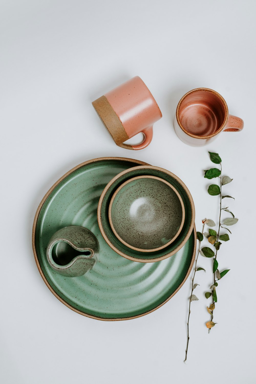 grüner Keramikbecher auf grüner Keramikuntertasse