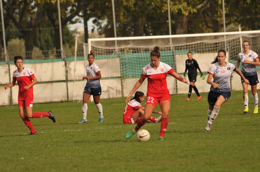 women playing soccer on field during daytime