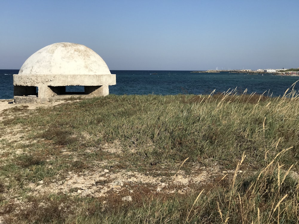 white dome tent on green grass field near sea during daytime