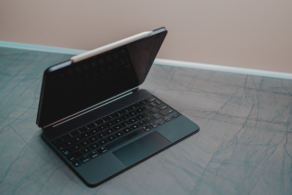 black laptop computer on white textile