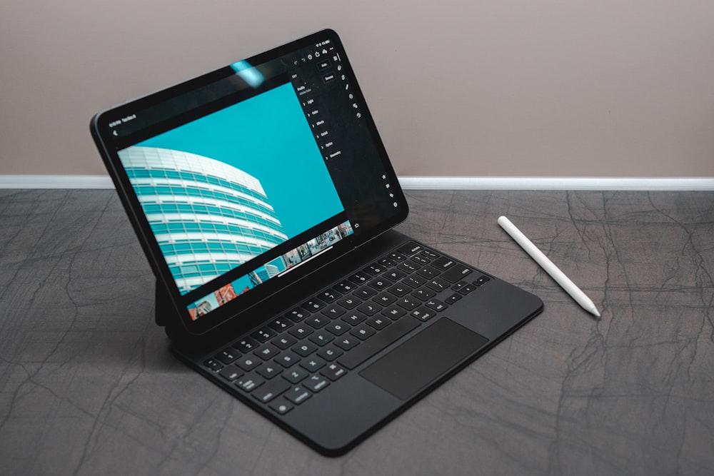 Schwarzer Laptop-Computer auf weißem Textil eingeschaltet