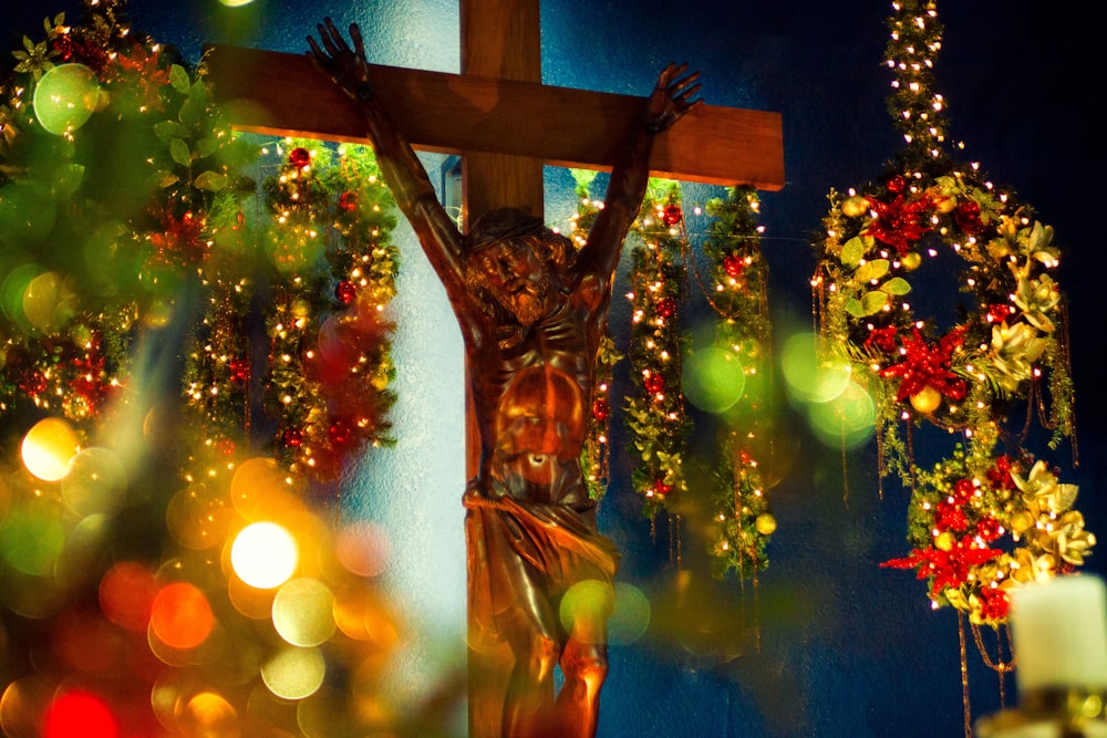 gold angel statue near green christmas tree with string lights