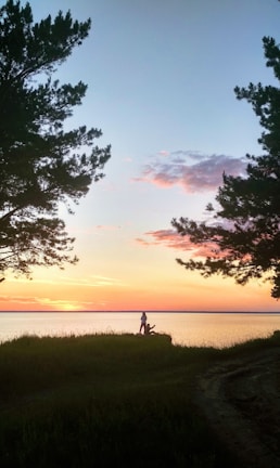 A serene lakeside moment at sunset with a companion and traveler enjoying the view.