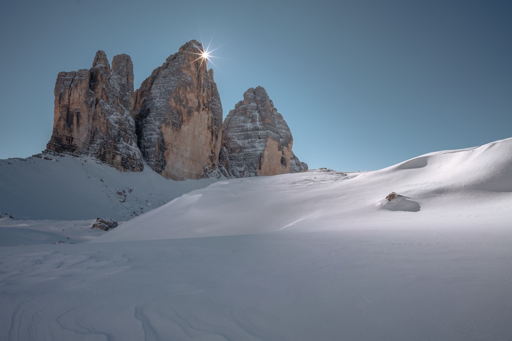 brown rocky mountain covered by snow under blue sky during daytime