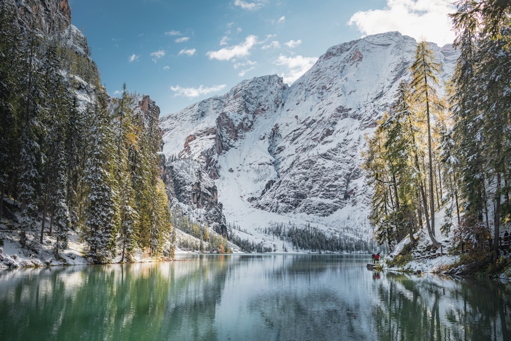 body of water near snow covered mountain during daytime