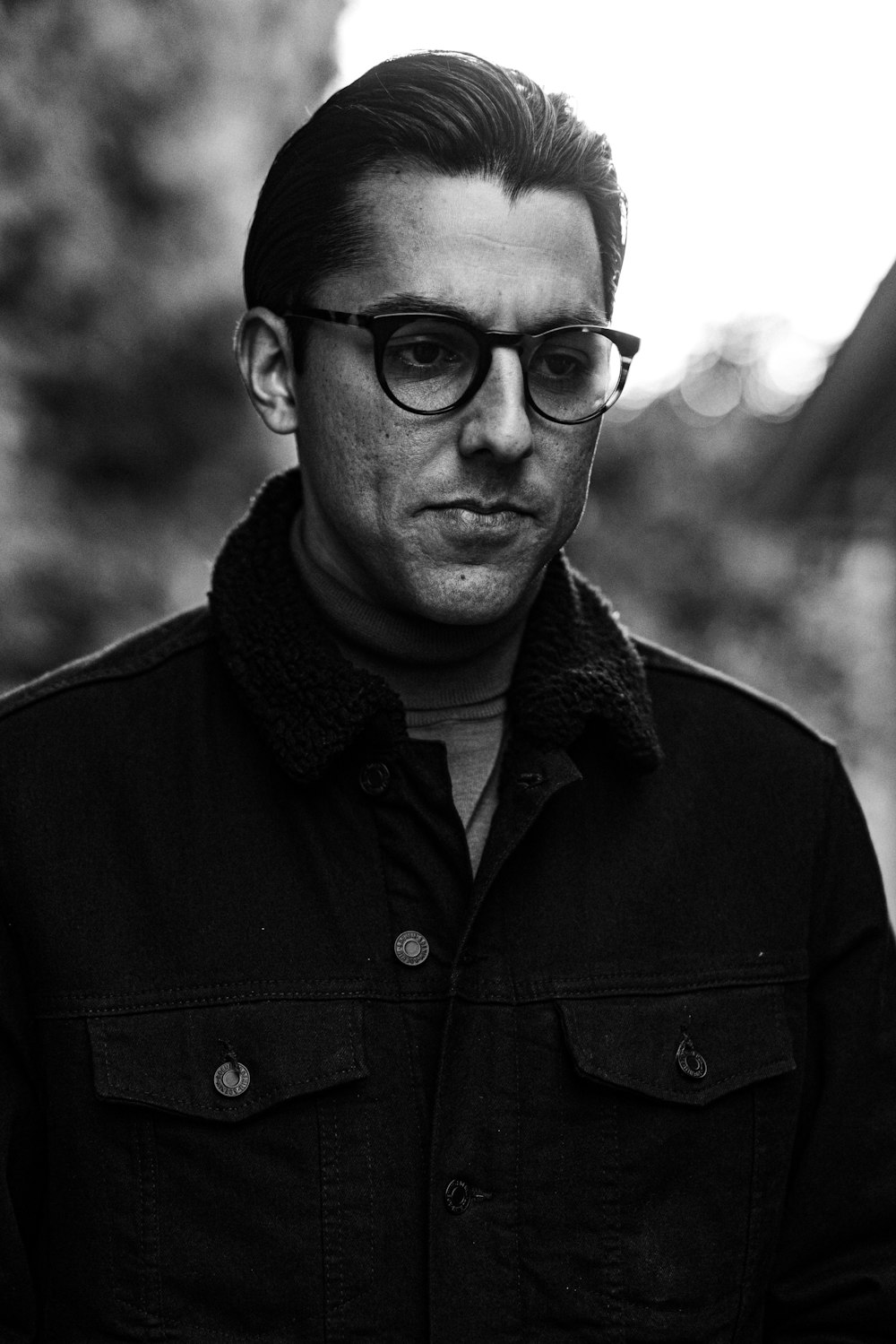 man in black button up shirt wearing black framed eyeglasses