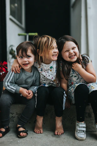 Kids sitting on colorful steps wearing flexty jeans and tees, sharing a story.