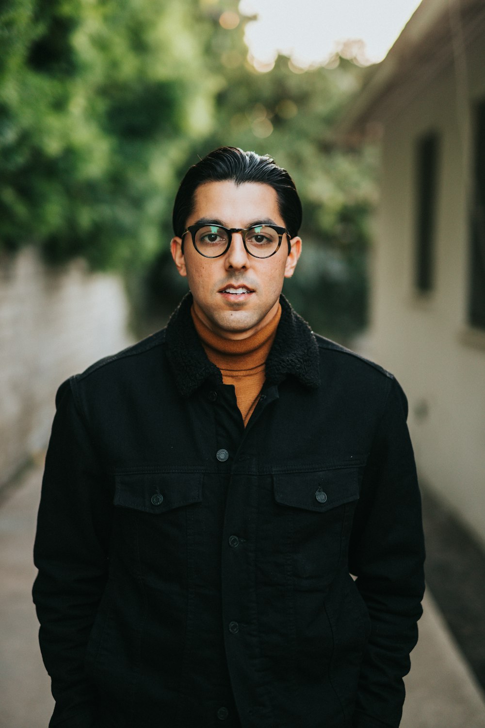 man in black button up jacket wearing black framed eyeglasses