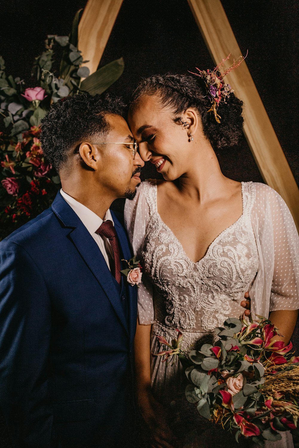 man in black suit kissing woman in white floral dress