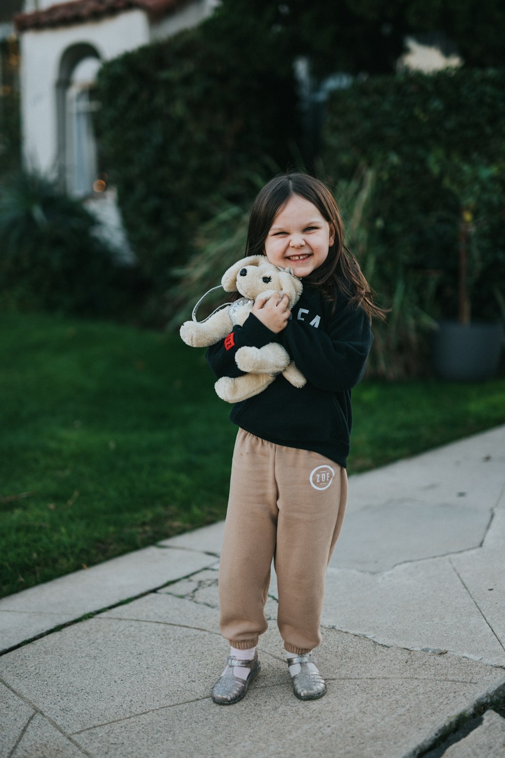 girl in black long sleeve shirt holding white bear plush toy