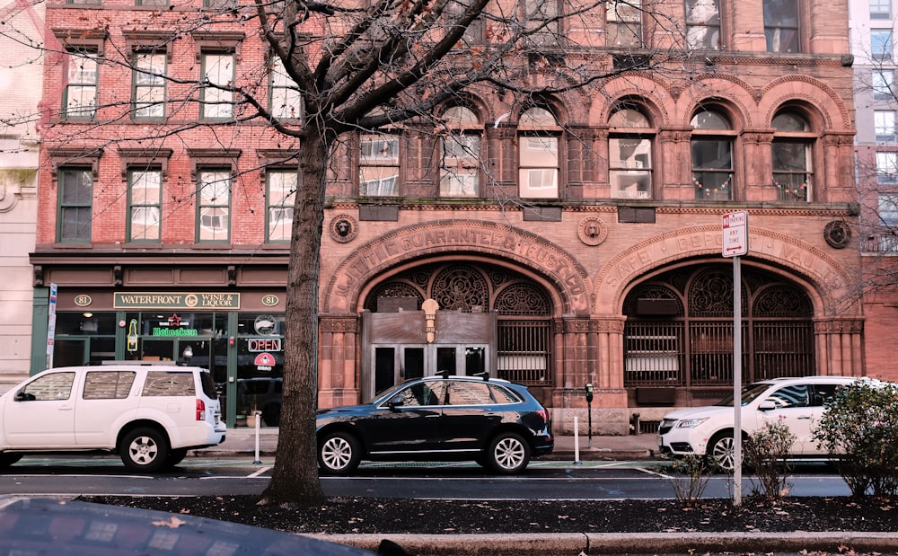 blue sedan parked beside brown concrete building during daytime