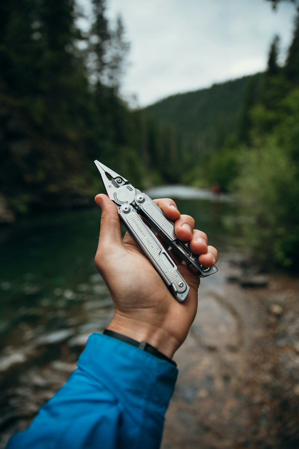 person holding silver and black hand tool