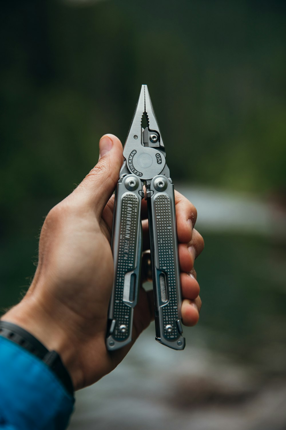 person holding silver and orange multi tool