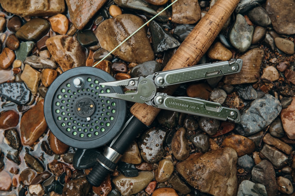 a pair of scissors sitting on top of a pile of rocks