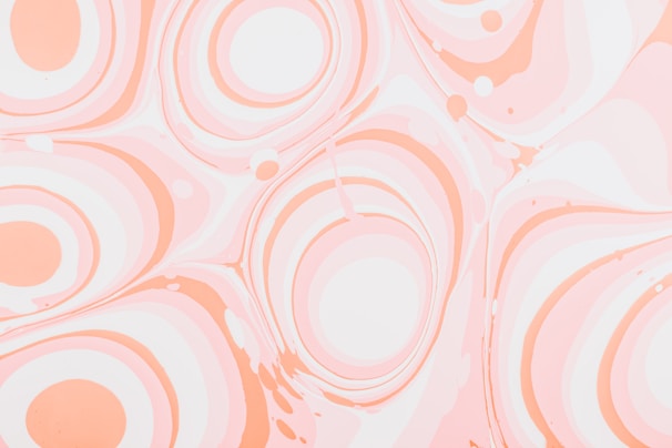 Swirling patterns of smooth, pastel-colored circles and waves create a marbled effect. The design consists primarily of soft oranges and pinks against a lighter background, giving a sense of fluidity and calm.