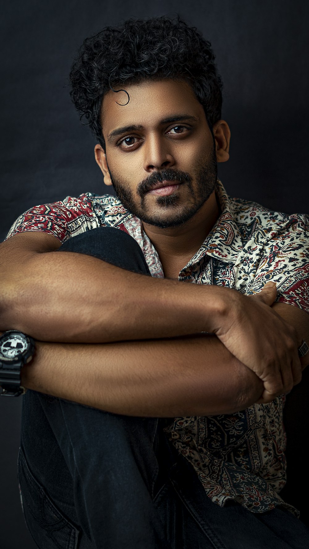 man in black vest and white and red floral shirt