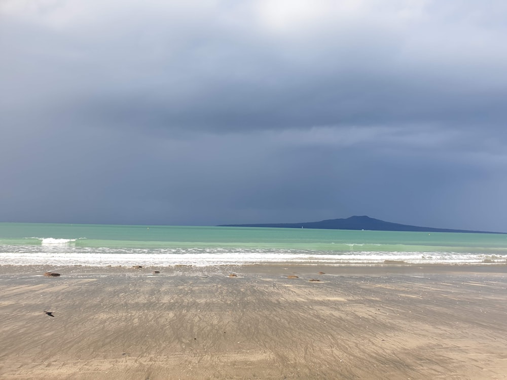 brown sand beach under cloudy sky during daytime