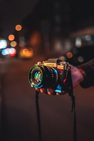 Close-up of vintage camera lens reflecting neon city lights with subtle VHS glitch effects.