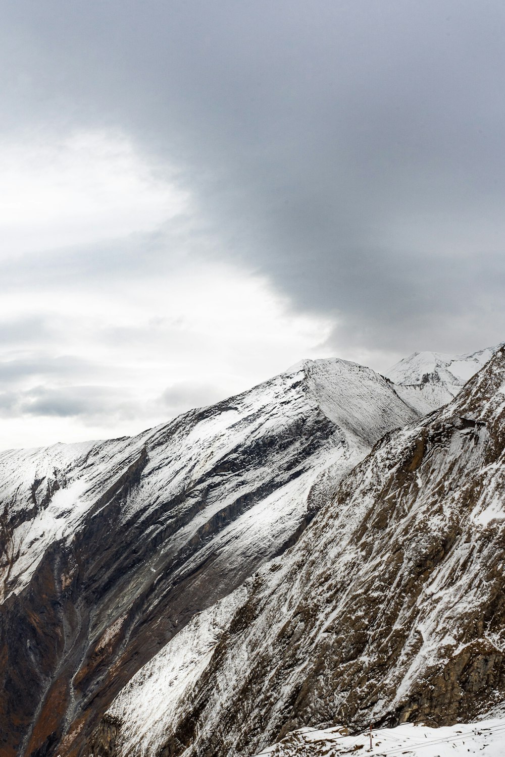 snow covered mountain under cloudy sky during daytime