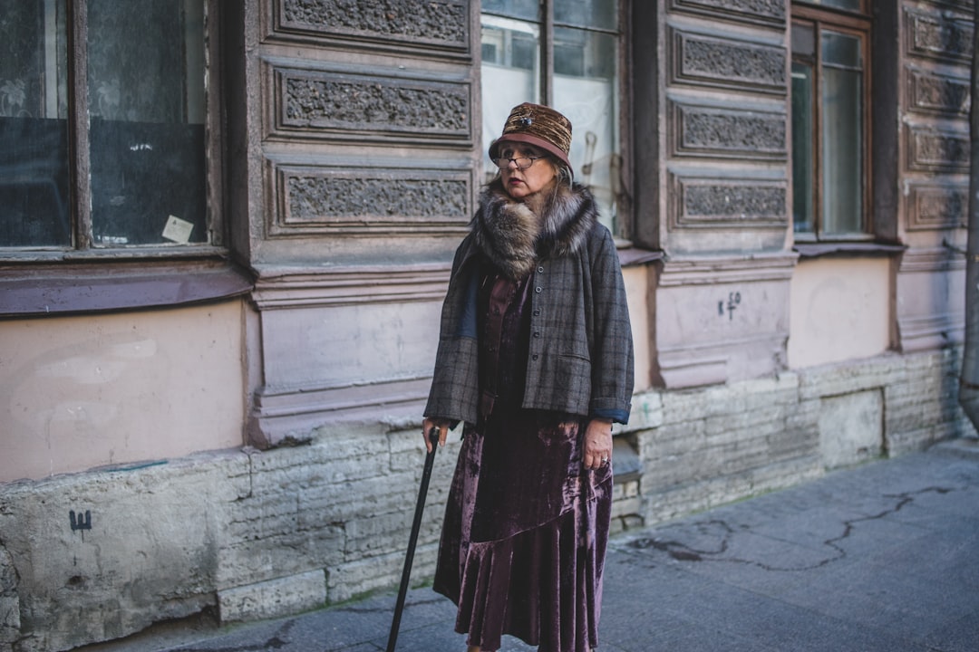 woman in black and brown scarf standing on sidewalk during daytime