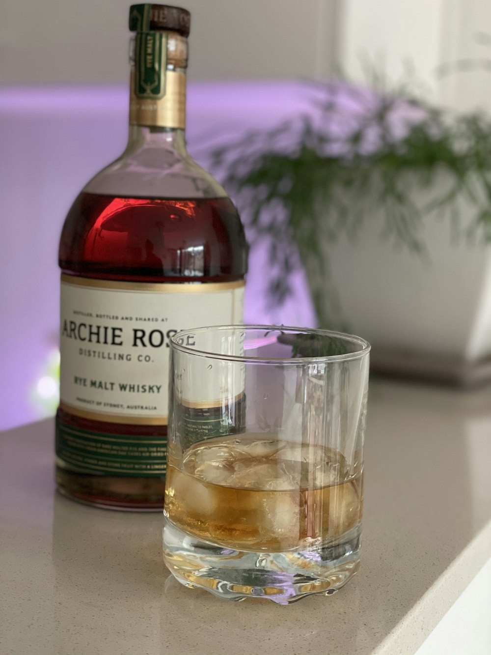 a bottle of alcohol and a glass on a counter