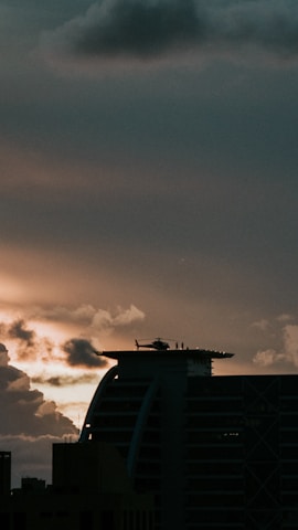 A sleek helicopter poised on a helipad at sunset, symbolizing the elevated standard of Travuxe Eminence.