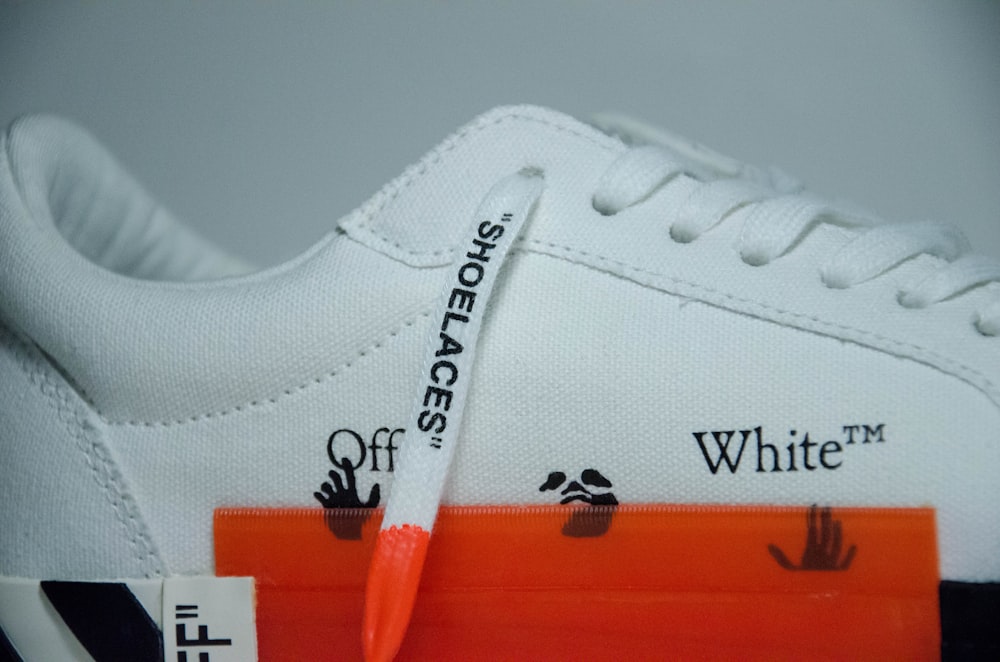white and orange nike athletic shoe