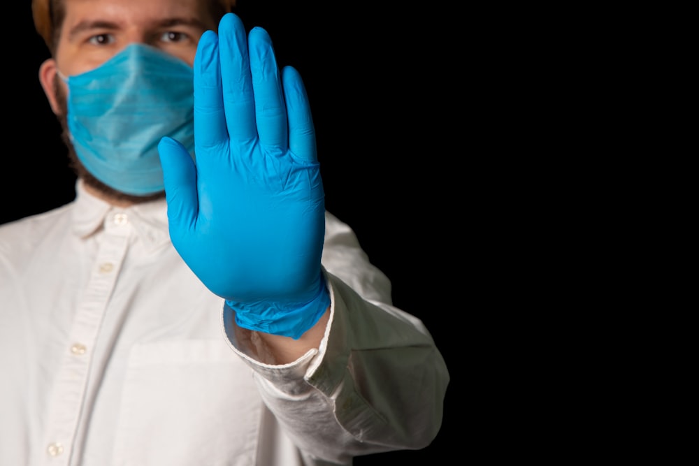 person in white long sleeve shirt covering face with blue textile