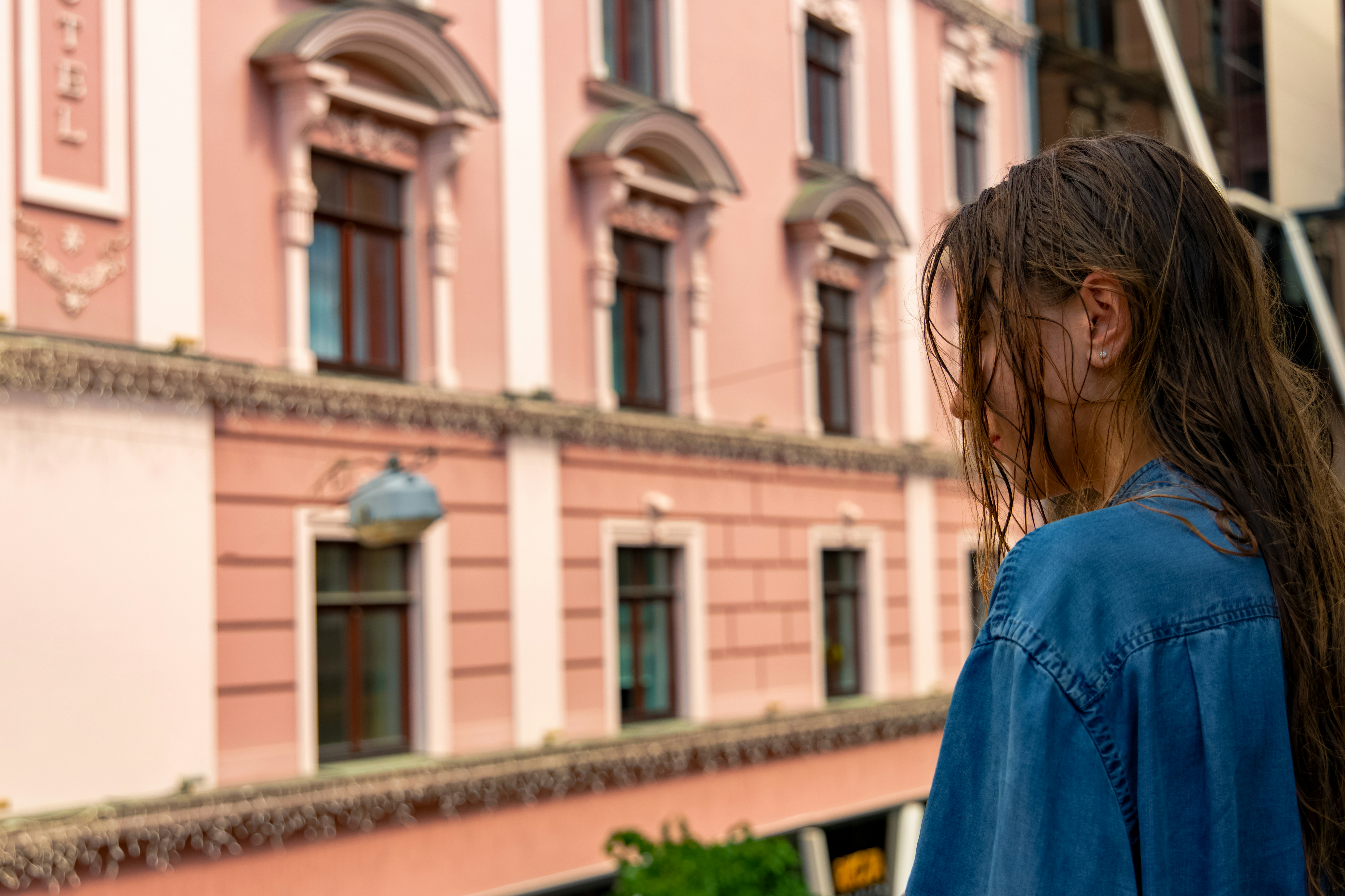 morning girl portrait with wet hair after shower profile face back to camera and old city architecture urban landmark view background space