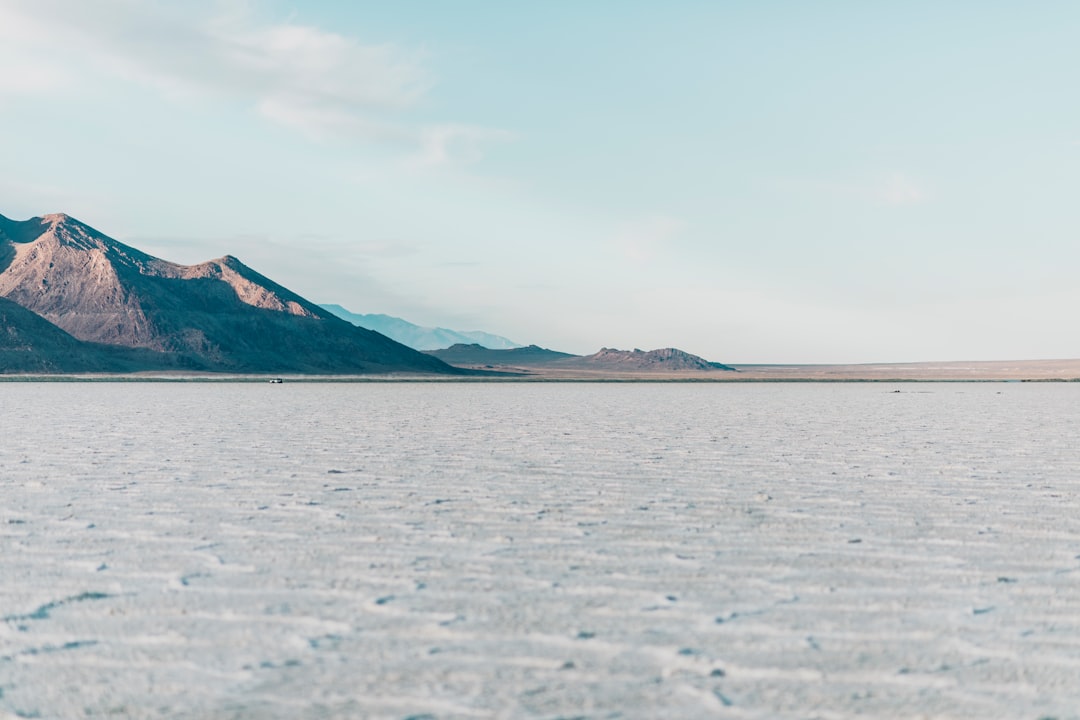 brown mountain near body of water during daytime