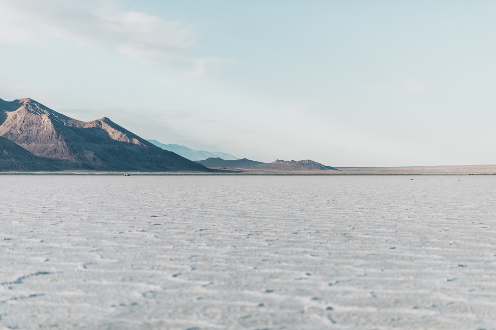 brown mountain near body of water during daytime